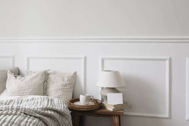 Cup of coffee, lampshades with linen shades, vintage wooden nightstand.
