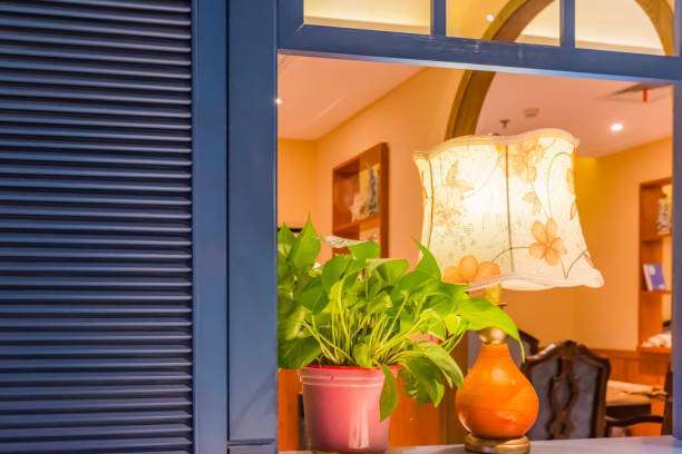 The warm light from the lamp shades shone on the potted plant.