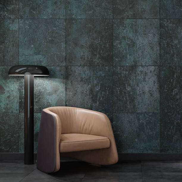 Stylish modern minimal interior featuring a sculptural armchair, black floor lamp, and a textured wall clad in large stone tiles arranged in a staggered pattern. The warm lighting fabric lamp shades
