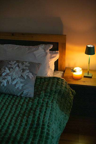 Bedside lamp with decorative lamp shades and snowflake pillow.