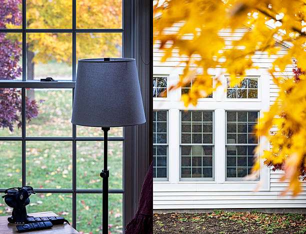 Floor lamp with a grey lamp shade by a window showing vibrant autumn trees.