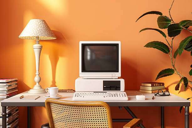 Vintage desk setup with an old computer, a white table lamp, and its elegant lamp shades.