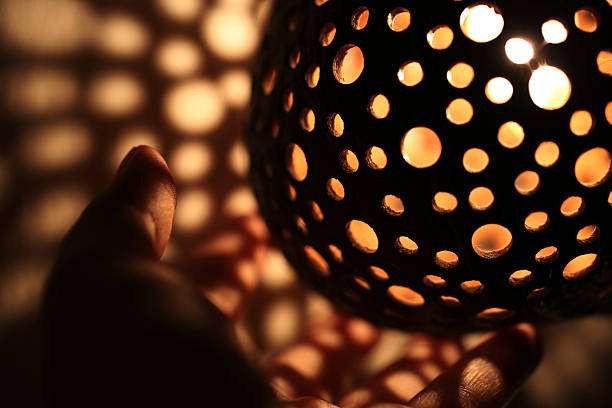 Ornate spherical lamp shade with light casting patterned shadows.