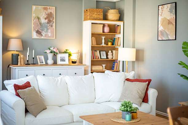 Cozy living room with a white sofa, warm lighting, and multiple stylish lamp shades.